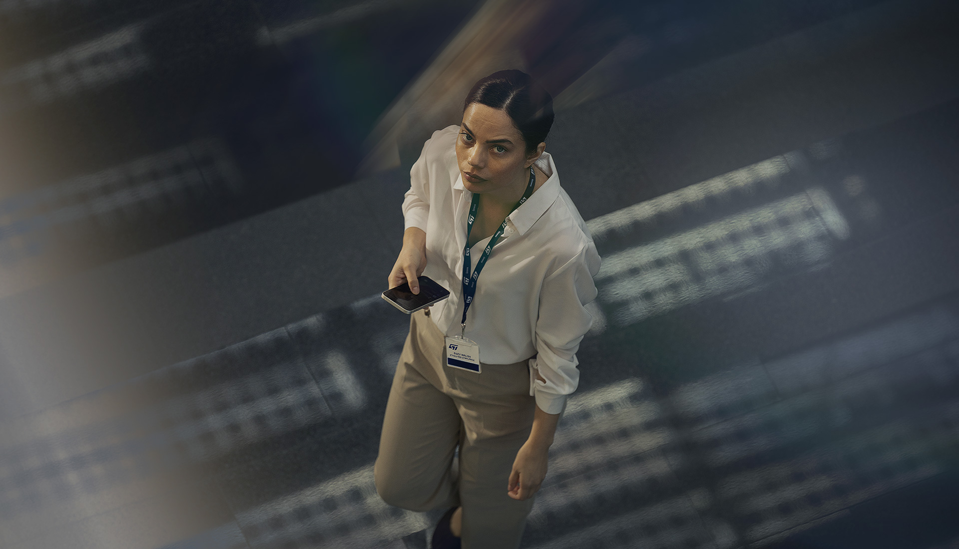 Suzie walking through a server room, looking at her phone